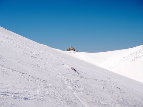 The top of the mountain Helmos in Kalavrita ski resort with snow and clouds in a sunny day