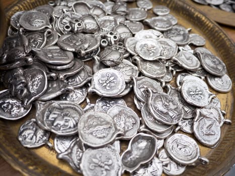 Close up of replica old silver coins in a pot as souvenirs 