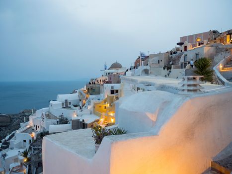 Small white houses with lights late in the afternoon in Oia, Santorini island,Greece