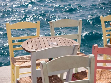 Close up of a wooden table and chairs by the sea