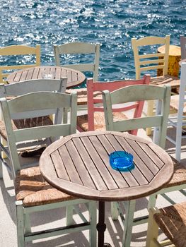 Close up of a wooden table and chairs by the sea