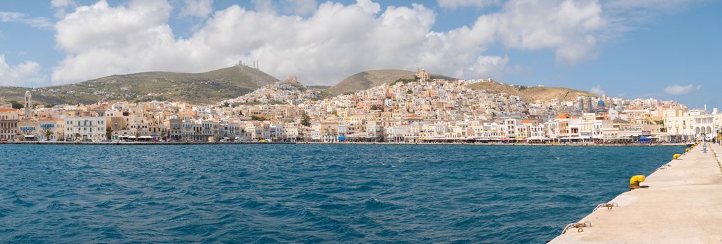 SYROS, GREECE - APRIL 10, 2016: View of Syros port with beautiful buildings and houses in a sunny day with clouds