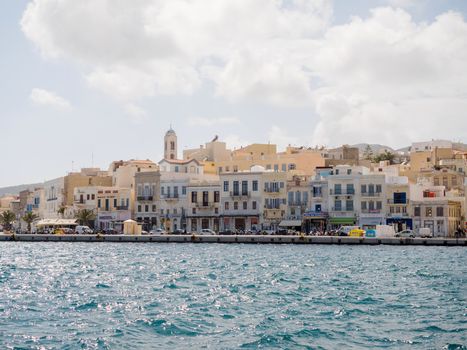 SYROS, GREECE - APRIL 10, 2016: View of Syros port with beautiful buildings and houses in a sunny day with clouds