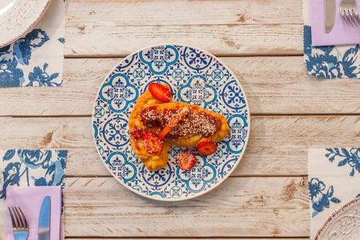 Gourmet greek cheese pie with tomato marmelade and strawberries served on a plate with pattern