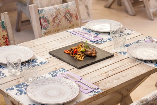 Grilled steak served with rice and vegetables on a graphite plate