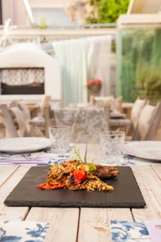 Grilled steak served with rice and vegetables on a graphite plate