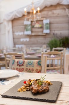 Grilled steak served with rice and vegetables on a graphite plate