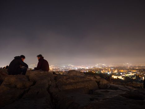 ATHENS, GREECE - MARCH 30,2016: People enjoying the view of Athens city by night from Areopagus hill near Acropolis