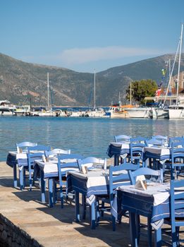 FISKARDO, GREECE - AUGUST 20, 2016: Restaurant tables by the sea in Fiskardo village in Kefalonia island, Greece