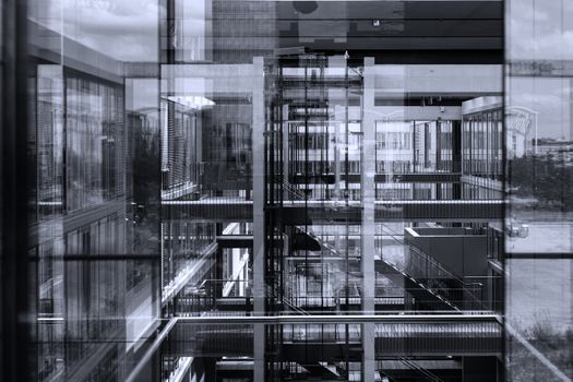 Abstract window reflections in morden office building. Contemporary corporate business architecture. Black and white, blue toned image.