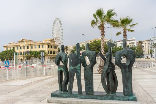 Stone statue sculpture overlooking the giant wheel in the city of Malaga, Spain, Europe  on a cloudy morning
