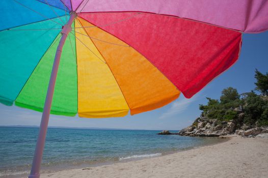 A colorful umbrella on a quiet beautiful beach by the sea.