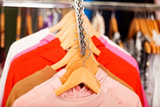 Closeup shot of clothes hang on a shelf in modern fashion store