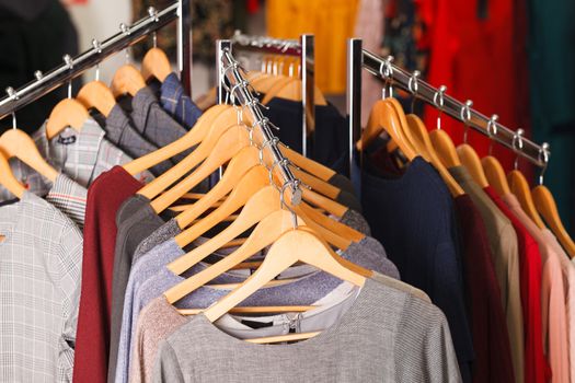 Closeup shot of clothes hang on a shelf in modern fashion store