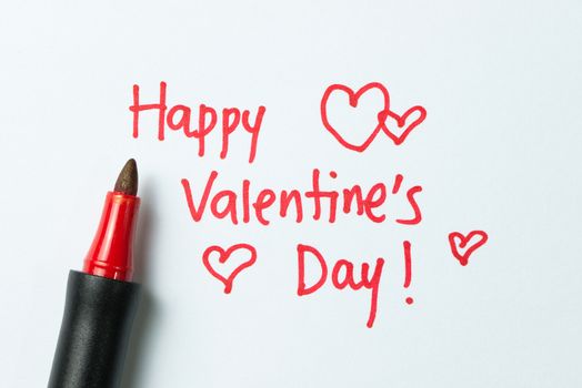 Happy Valentine's day written on white paper using red color pen