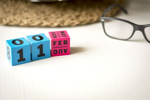 modern perpetual calendar composed of colored cubes and set at the date of February 11th