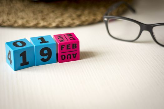 modern perpetual calendar composed of colored cubes and set at the date of February 19th