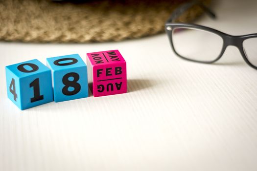 modern perpetual calendar composed of colored cubes and set at the date of February 18th