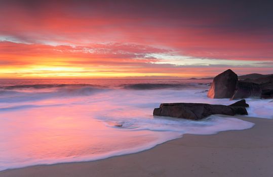 Beautiful beach glowing in the morning sunrise with colours of reds, orange, yellow, so pretty.  Location - Box Beach