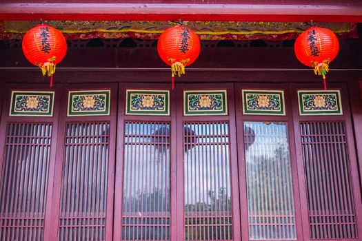 Traditional Chinese Building with Chinese Artwork on Doors and Lanterns Above.