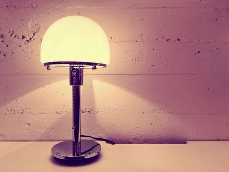 Lamp with round lampshade near concrete wall. Contemporary design.