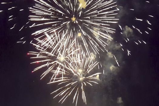 Festive salute in the night sky. Explosions of fireworks.