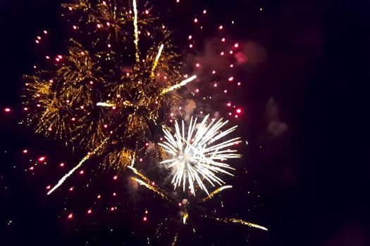 Festive salute in the night sky. Explosions of fireworks.