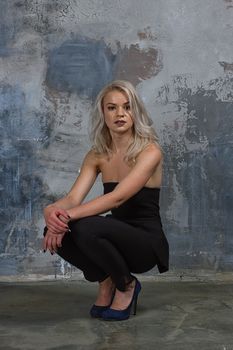 Portrait of a girl with long hair in youth clothes, Young beautiful girl near the wall her back