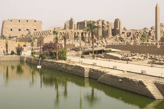 A pond near the ancient Egyptian buildings and ruins.