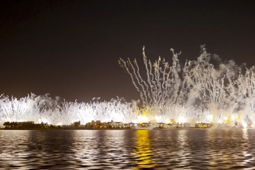 Festive firework in Dubai. Beautiful colorful holiday fireworks in the evening sky with majestic clouds, long exposure