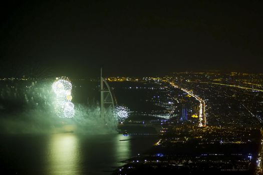 Festive firework in Dubai. Beautiful colorful holiday fireworks in the evening sky with majestic clouds, long exposure