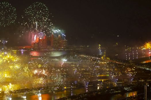 Festive firework in Dubai. Beautiful colorful holiday fireworks in the evening sky with majestic clouds, long exposure