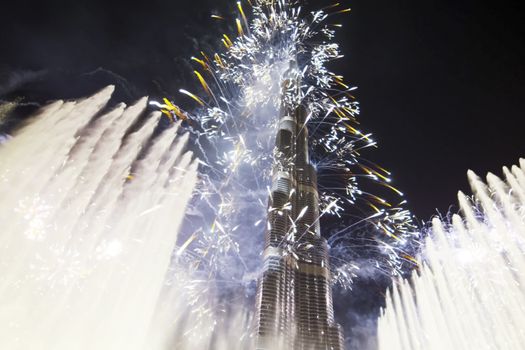 Festive firework in Dubai. Beautiful colorful holiday fireworks in the evening sky with majestic clouds, long exposure