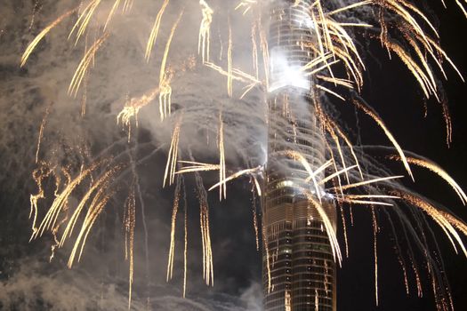 Festive firework in Dubai. Beautiful colorful holiday fireworks in the evening sky with majestic clouds, long exposure