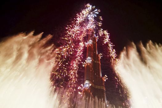 Festive firework in Dubai. Beautiful colorful holiday fireworks in the evening sky with majestic clouds, long exposure