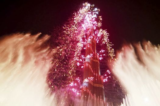 Festive firework in Dubai. Beautiful colorful holiday fireworks in the evening sky with majestic clouds, long exposure