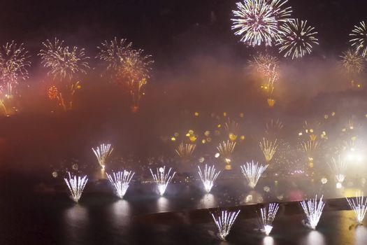 Festive firework in Dubai. Beautiful colorful holiday fireworks in the evening sky with majestic clouds, long exposure