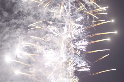 Festive firework in Dubai. Beautiful colorful holiday fireworks in the evening sky with majestic clouds, long exposure