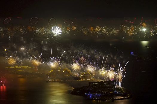 Festive firework in Dubai. Beautiful colorful holiday fireworks in the evening sky with majestic clouds, long exposure