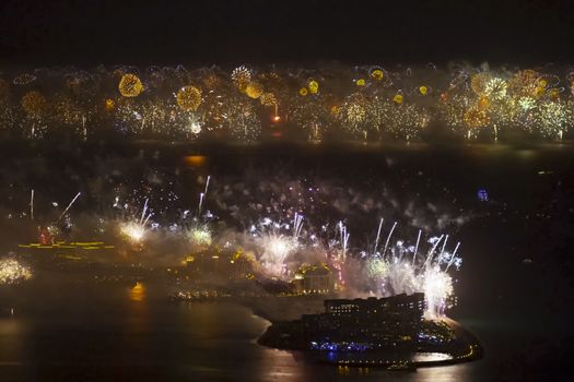 Festive firework in Dubai. Beautiful colorful holiday fireworks in the evening sky with majestic clouds, long exposure