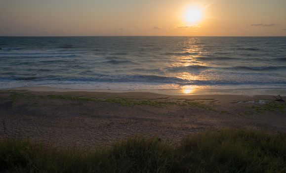 Beautiful empty beach on the sea or ocean shore on sunrise.