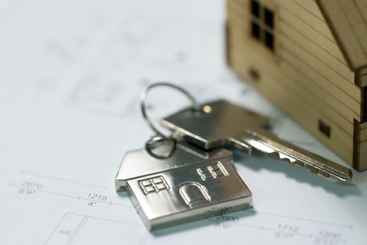 House key with house model keychain on house layout plan