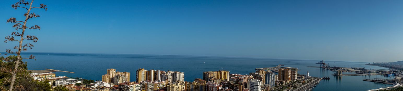 Panorama City skyline and harbour, sea port of Malaga overlooking the sea ocean in Malaga, Spain, Europe  on a summer day with blue sky