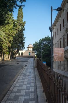 Stone pathway leading down the hill overlooking Malaga, Spain, Europe with trees on either side on a bright summer day