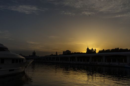 The docking harbour of Malaga with sun set in the background in Malaga, Spain, Europe at the golden hour