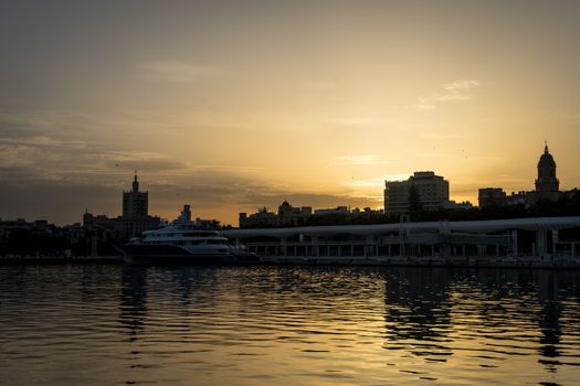 The docking harbour of Malaga with sun set in the background in Malaga, Spain, Europe at the golden hour