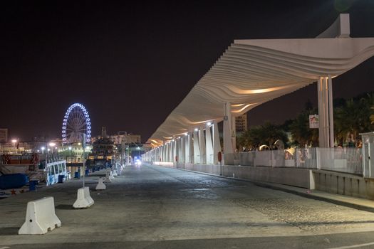 The walking path illuminated with the giant wheel with light and illumination at Malaga, Spain, Europe at night