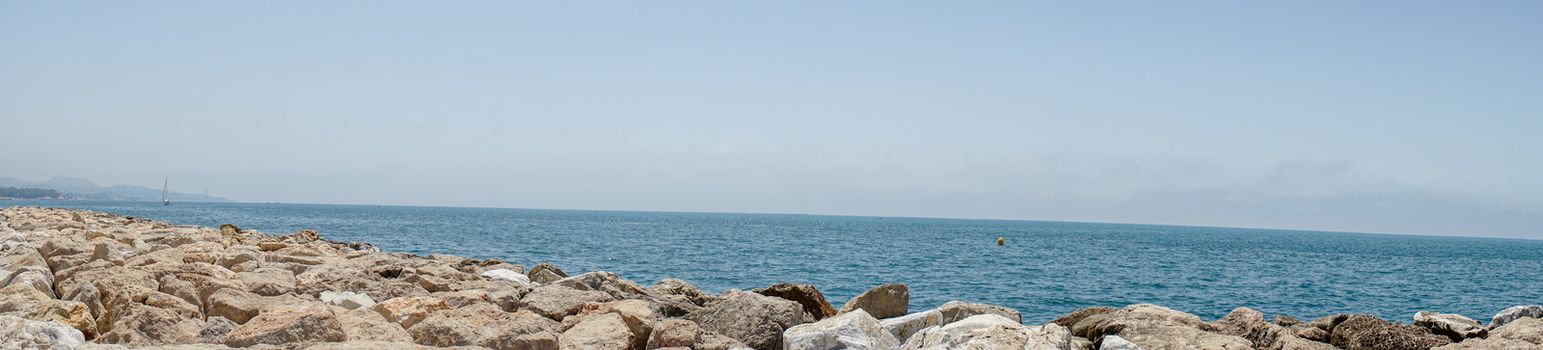 Panoramic view of the ocean at Malagueta beach with rocks at Malaga, Spain, Europe on a clear sky morning