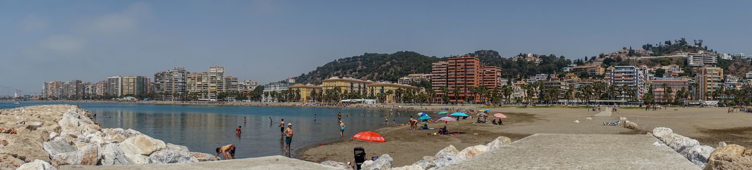 Panoramic view of the ocean at Malagueta beach with rocks at Malaga, Spain, Europe on a clear sky morning