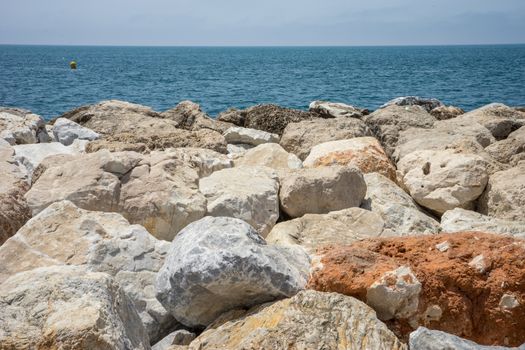 Rocks against the green ocean at Malagueta beach in malaga, Spain, Europe with clear sky in the morning